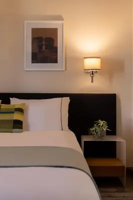 a bedroom with a white bed with a lamp and a table at Mia Homes - Athens Riviera at Voula Center in Athens