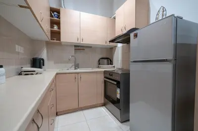 a kitchen with a refrigerator and a sink at City Base for 2 - Kolonos near Metro by ΜΡS in Athens