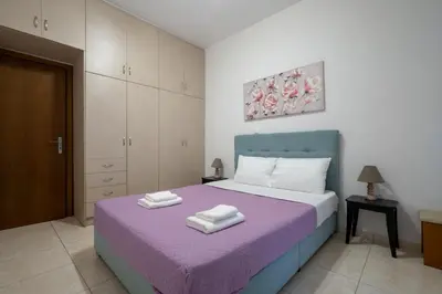 a bedroom with a purple bed with towels on it at City Base for 2 - Kolonos near Metro by ΜΡS in Athens