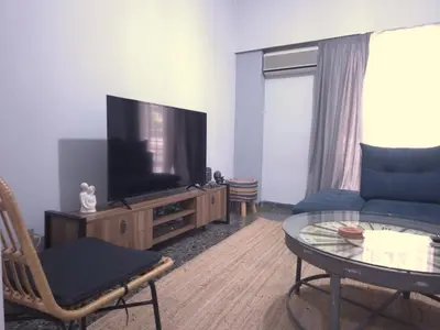 a living room with a couch and a television at The Cozy Blue Flat in Athens
