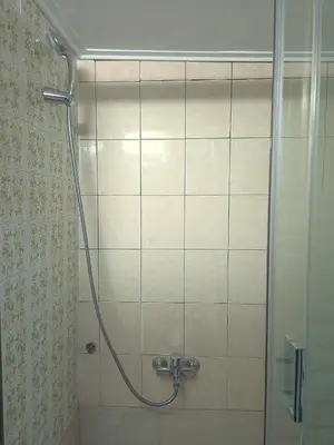 a shower with a hose in a bathroom at The Cozy Blue Flat in Athens