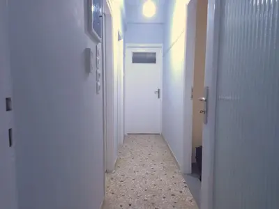 a corridor of a hallway with a white door at The Cozy Blue Flat in Athens
