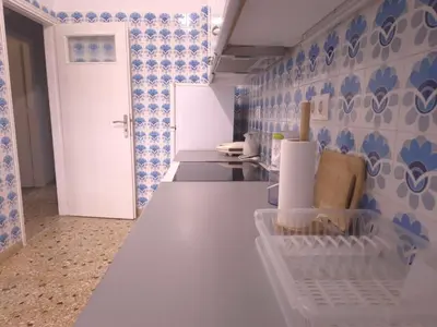 a kitchen with a white counter and blue tiles at The Cozy Blue Flat in Athens