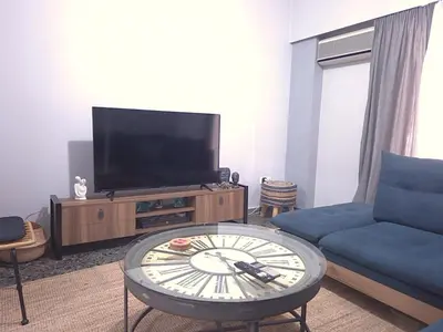 a living room with a tv and a coffee table at The Cozy Blue Flat in Athens