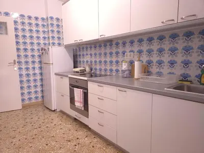 a kitchen with white cabinets and blue and white tiles at The Cozy Blue Flat in Athens