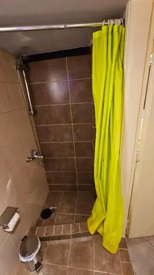 a shower with a yellow shower curtain in a bathroom at Cozy Smart studio apartment in Athens in Athens
