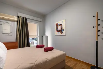 a bedroom with a bed with two red pillows on it at Petralona 2BDRM -Easy Access to City Center by ΜΡS in Athens