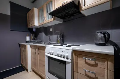 a kitchen with a white stove and wooden cabinets at Petralona 2BDRM -Easy Access to City Center by ΜΡS in Athens