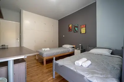 a bedroom with two beds and a counter with towels at Petralona 2BDRM -Easy Access to City Center by ΜΡS in Athens