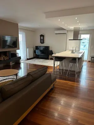 a living room with a couch and a table at Glyfada Top-Floor 2BR, Sea and City Views in Athens