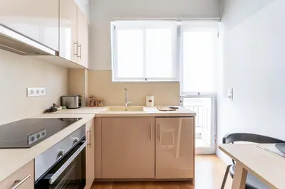 a kitchen with white cabinets and a sink at Urban Grace - In the Heart of Athens in Athens