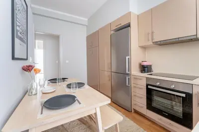 a kitchen with a wooden table and a counter top at Urban Grace - In the Heart of Athens in Athens