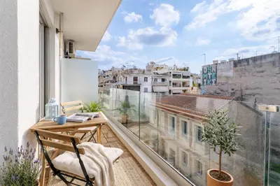a balcony with a desk and a view of a city at Urban Grace - In the Heart of Athens in Athens