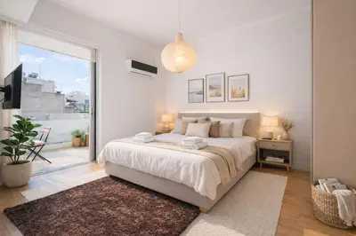 a white bedroom with a large bed and a balcony at Urban Grace - In the Heart of Athens in Athens