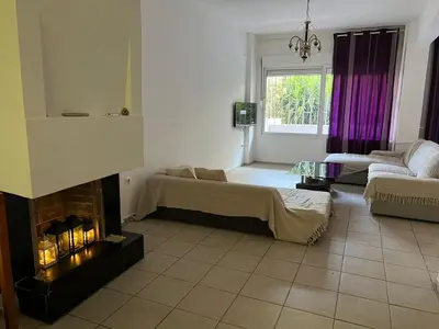 a living room with a fireplace and a couch at Athenian Maisonette near Metro & shops in Athens