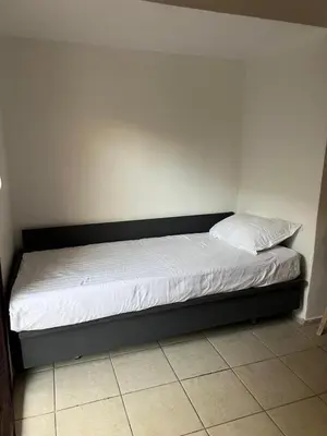 a bed in a room with white sheets and pillows at Athenian Maisonette near Metro & shops in Athens