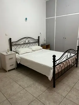 a bedroom with a black bed and a night stand at Athenian Maisonette near Metro & shops in Athens