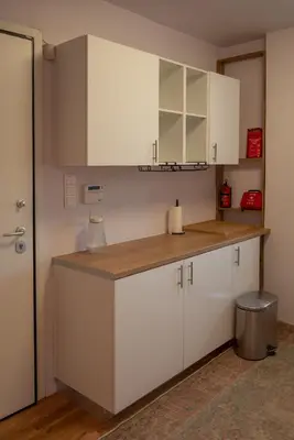 a kitchen with white cabinets and a counter top at Villa Tata - Private Pool, Garden & Mountain View near the Sea in Metókhi