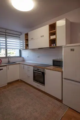 a kitchen with white cabinets and a white refrigerator at Villa Tata - Private Pool, Garden & Mountain View near the Sea in Metókhi