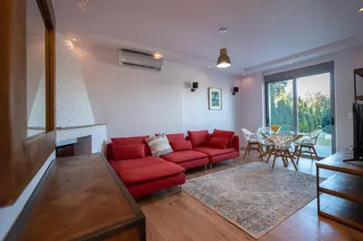 a living room with a red couch and a table at Villa Tata - Private Pool, Garden & Mountain View near the Sea in Metókhi