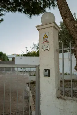 a stone pillar with a sign on it next to a fence at Villa Tata - Private Pool, Garden & Mountain View near the Sea in Metókhi