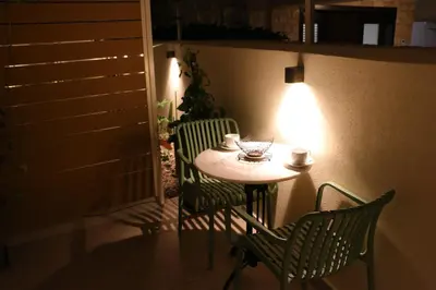 a small table with two chairs and a light at FaliroRelax F1 in Athens