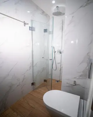 a white bathroom with a shower and a toilet at Tettix Athens Appartment B1 in Athens