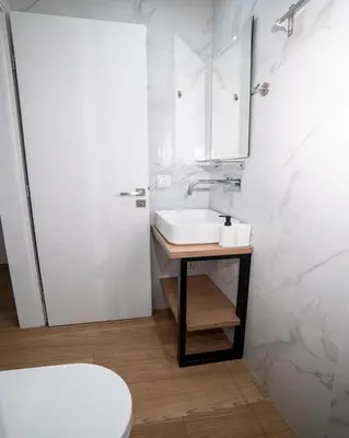 a white bathroom with a sink and a mirror at Tettix Athens Appartment B1 in Athens