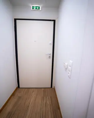 a white door in a room with a wooden floor at Tettix Athens Appartment B1 in Athens