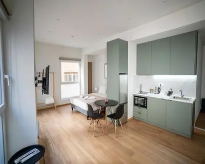 a room with a bed and a kitchen with a table at Tettix Athens Appartment B1 in Athens