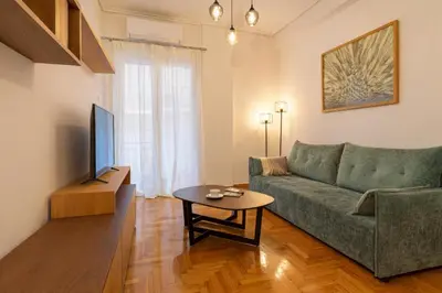 a living room with a green couch and a table at Stylish Kypseli Apartment Sleeps 4 300 Mbps WiFi in Athens