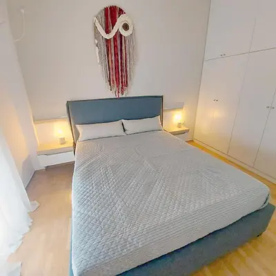 a large bed in a room with two lamps at Noeli Apartment by ΜΡS in Athens