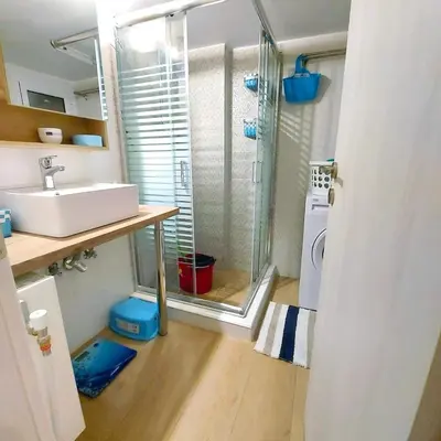 a bathroom with a sink and a glass shower at Noeli Apartment by ΜΡS in Athens