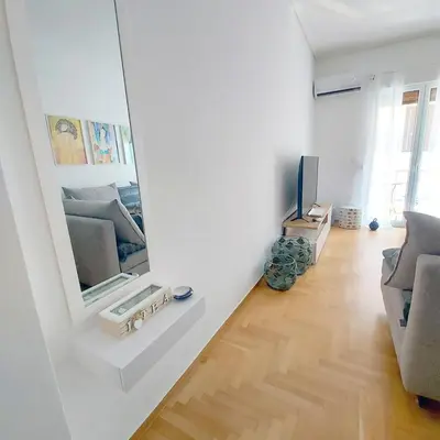 a living room with a mirror and a television at Noeli Apartment by ΜΡS in Athens