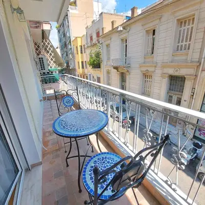 a balcony with tables and chairs on a balcony at Noeli Apartment by ΜΡS in Athens
