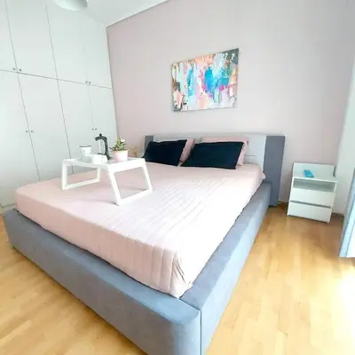 a bed with a white table on top of it at Noeli Apartment by ΜΡS in Athens