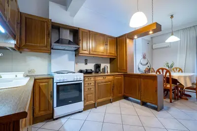 a kitchen with wooden cabinets and a white stove top oven at Authentic Athens stay in Kypseli by ΜΡS in Athens