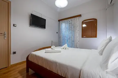 a bedroom with a white bed with a tv on the wall at Authentic Athens stay in Kypseli by ΜΡS in Athens