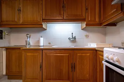 a kitchen with wooden cabinets and a sink at Authentic Athens stay in Kypseli by ΜΡS in Athens