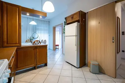 a kitchen with a white refrigerator and wooden cabinets at Authentic Athens stay in Kypseli by ΜΡS in Athens