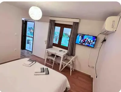 a room with two beds and a desk and a tv at Glyfada center apartment with private yard in Athens