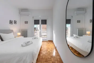 two beds in a room with a mirror at Colorful Koukaki Apartment Near the Acropolis in Athens
