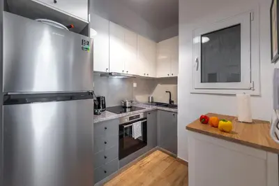 a kitchen with a refrigerator and fruits on a counter at Colorful Koukaki Apartment Near the Acropolis in Athens