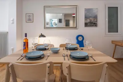 a dining room table with plates and wine glasses at Colorful Koukaki Apartment Near the Acropolis in Athens
