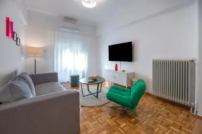 a living room with a couch and a green chair at Colorful Koukaki Apartment Near the Acropolis in Athens