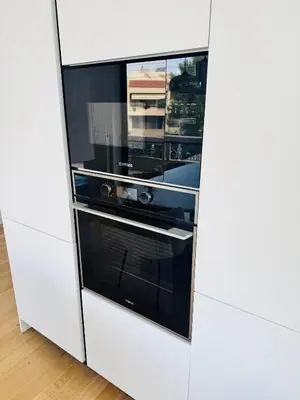 a white kitchen with an oven in a white cabinet at Glyfada Unique Luxury & Spacious Apartment in Athens