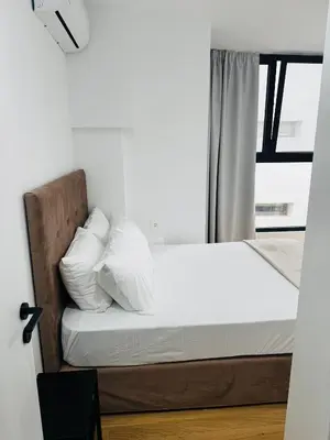 a bedroom with a bed with white pillows and a window at Glyfada Unique Luxury & Spacious Apartment in Athens