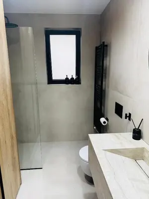 a bathroom with a sink and a toilet and a window at Glyfada Unique Luxury & Spacious Apartment in Athens