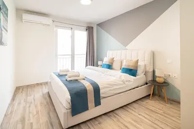 a bedroom with a white bed with blue accents at Athens Dimora Di Aristotele 2 in Athens