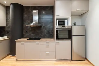 a kitchen with white cabinets and a refrigerator at Athens Dimora Di Aristotele 3 in Athens